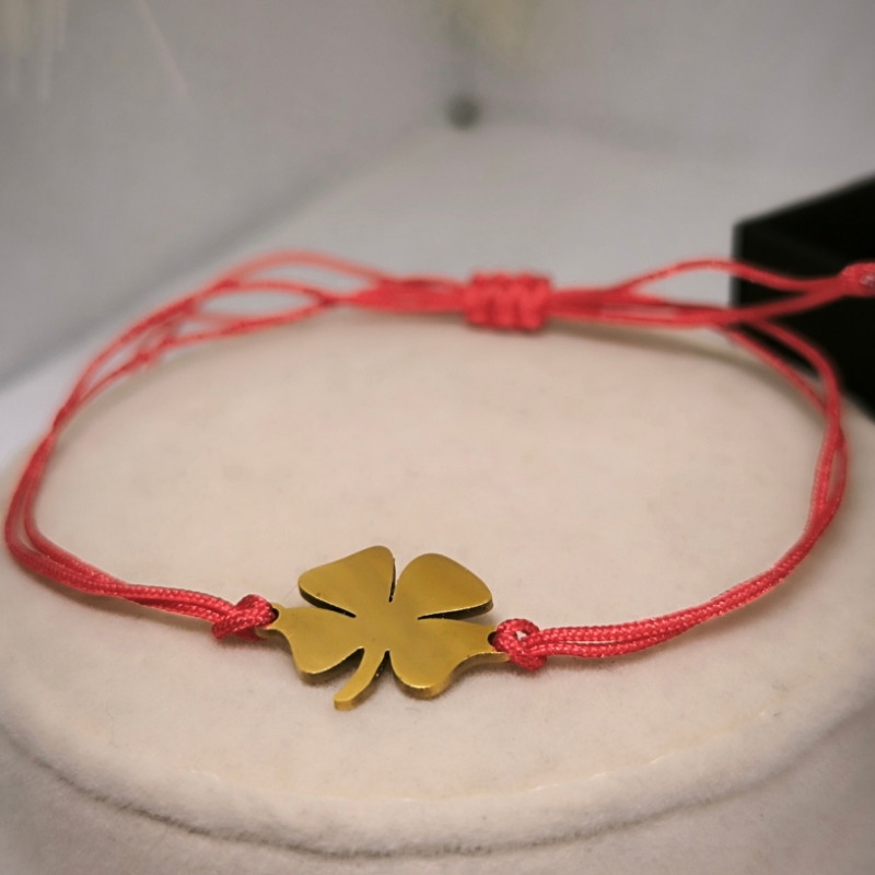 Sarkanā diega rokassprādze ar zelta krāsas četrplaukstu āboliņu