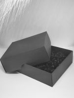 Melna dāvanu kastīte ar zelta lentīti