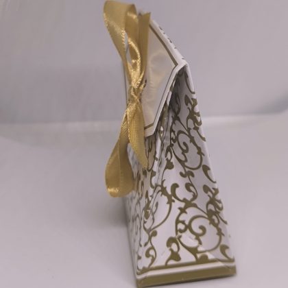 Balta dāvanu kastīte ar zelta ornamentiem un lentīti