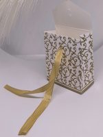 Balta dāvanu kastīte ar zelta ornamentiem un lentīti