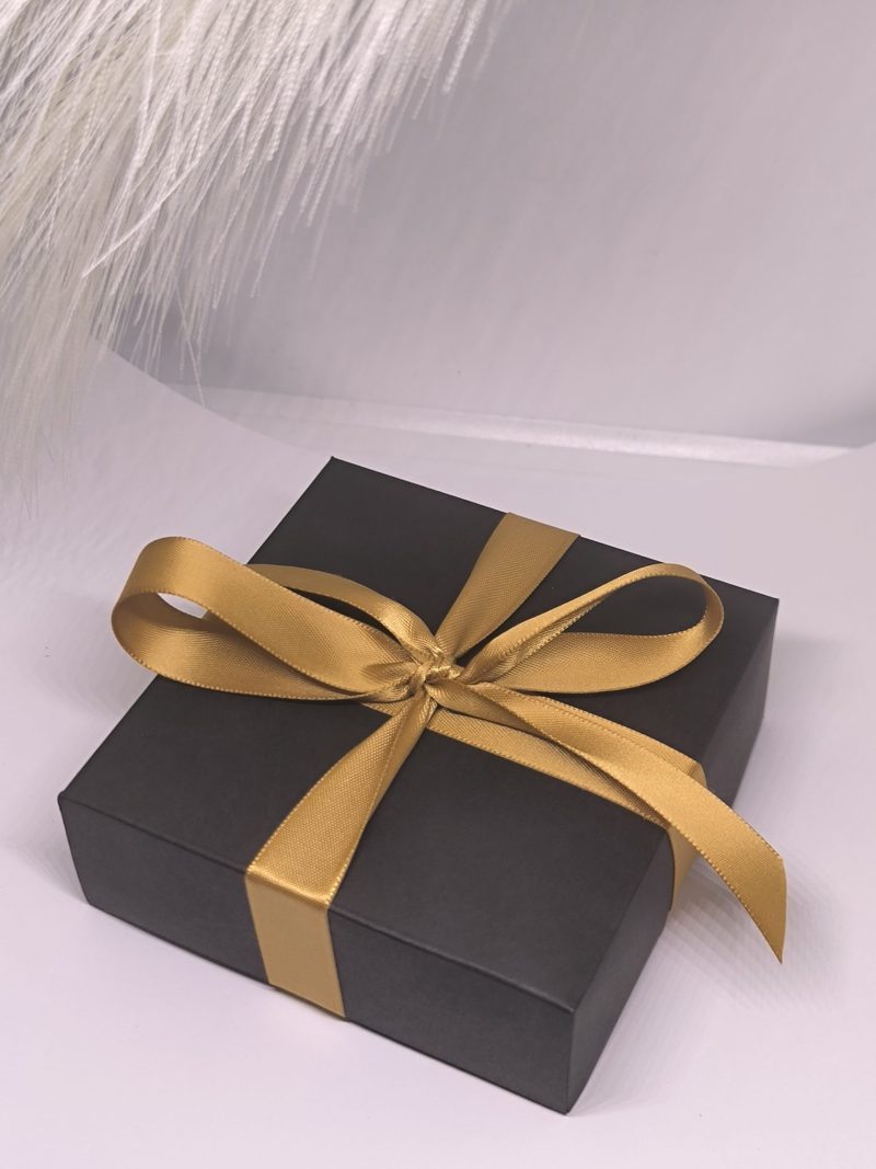 Melna dāvanu kastīte ar zelta lentīti