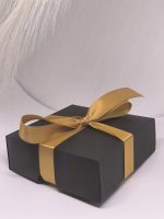Melna dāvanu kastīte ar zelta lentīti