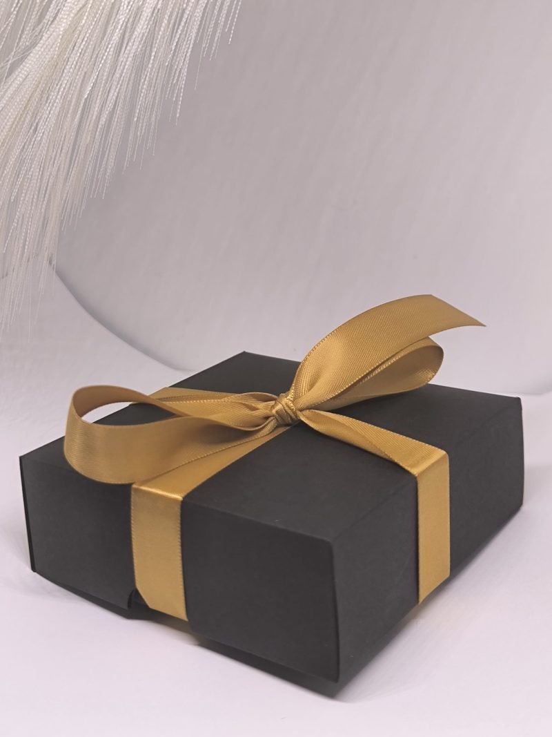 Melna dāvanu kastīte ar zelta lentīti
